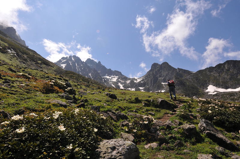 Rear view of man climbing on mountain against sky