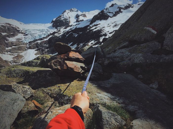 Cropped image of hiker holding rope at swiss alps