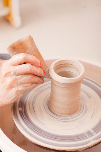 Cropped hand of girl making pottery