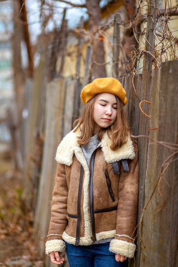 Portrait of young woman standing in forest during winter