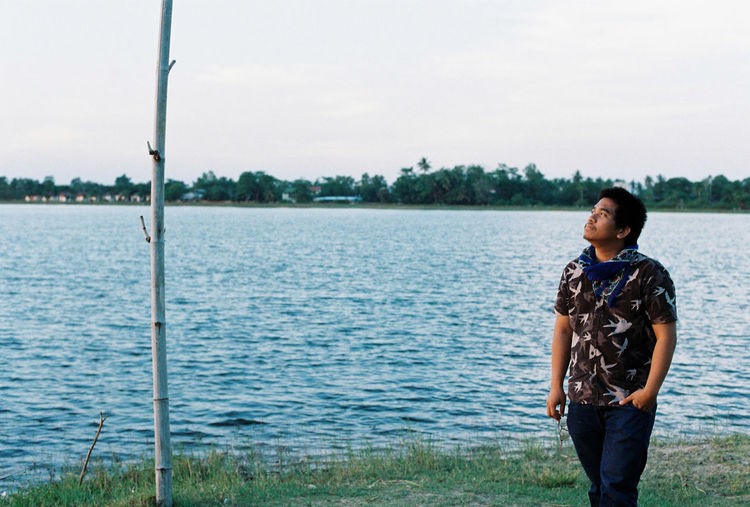Woman looking at lake against sky