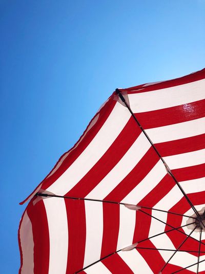 Low angle view of flag against blue sky
