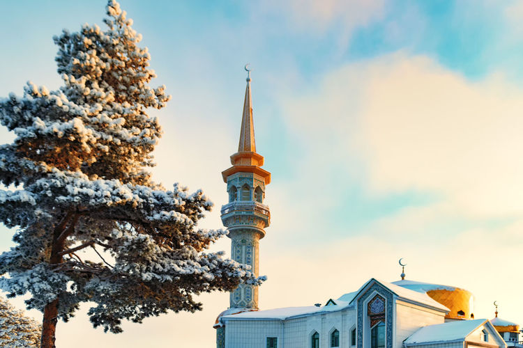 Low angle view of minaret mosque against sky