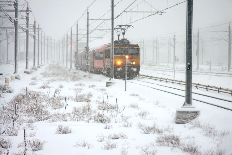 Train on snow covered railroad tracks during winter