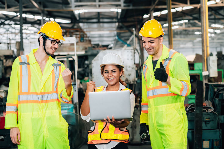People working with laptop in factory