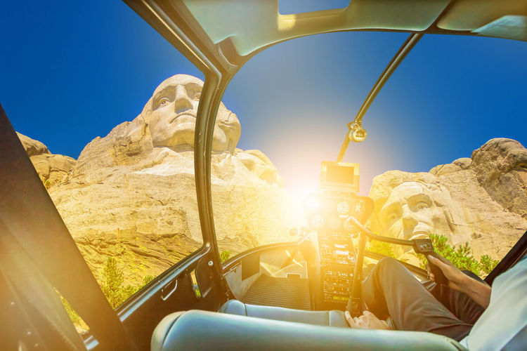 Digital composite image of man flying helicopter against mountain