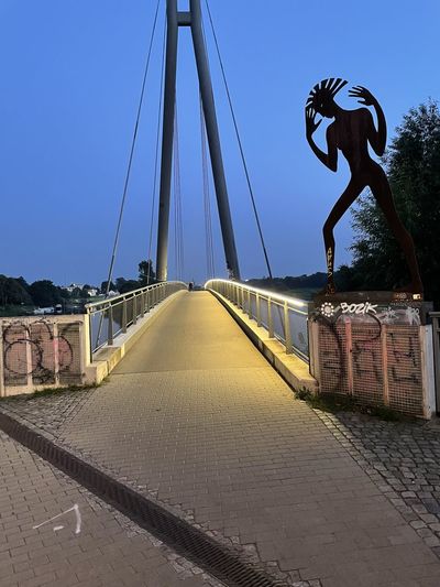 Man on bridge against sky