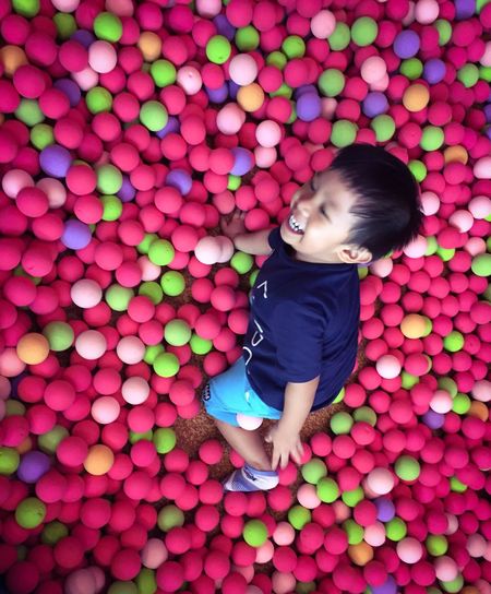 High angle view of boy playing in ball pool