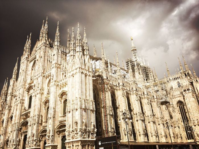 Low angle view of milan cathedral against cloudy sky