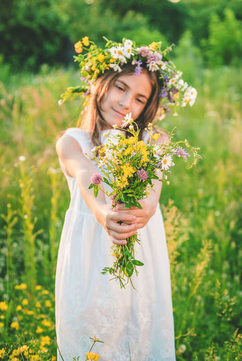 Girl wearing floral crown showing flowers