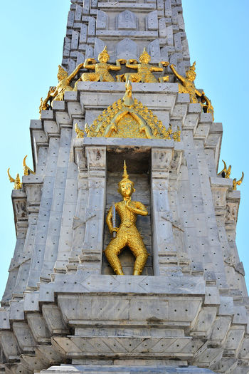 Low angle view of statue against temple building