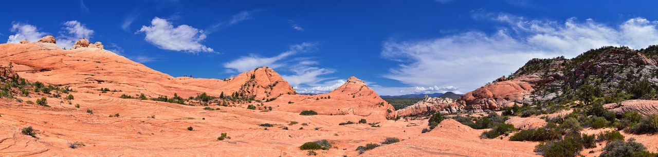 Panoramic view of rocky mountains against blue sky