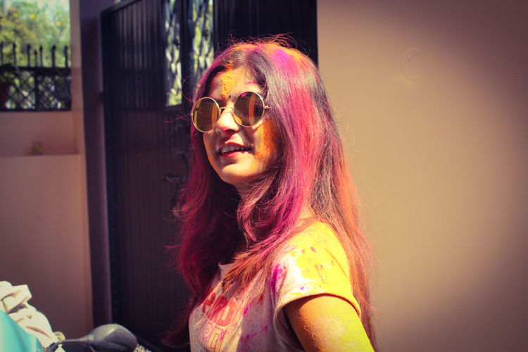 Portrait of woman wearing sunglasses holi festival