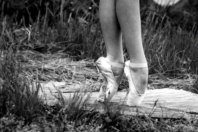 Low section of ballet dancer tiptoeing on footpath