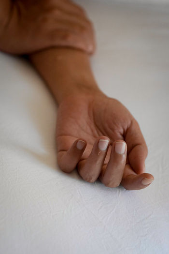 Cropped hand of person lying on bed