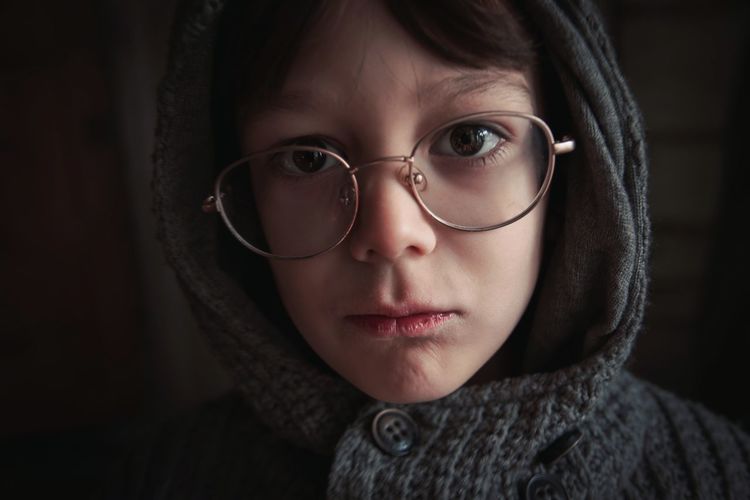 Close-up portrait of boy wearing warm clothing and eyeglasses