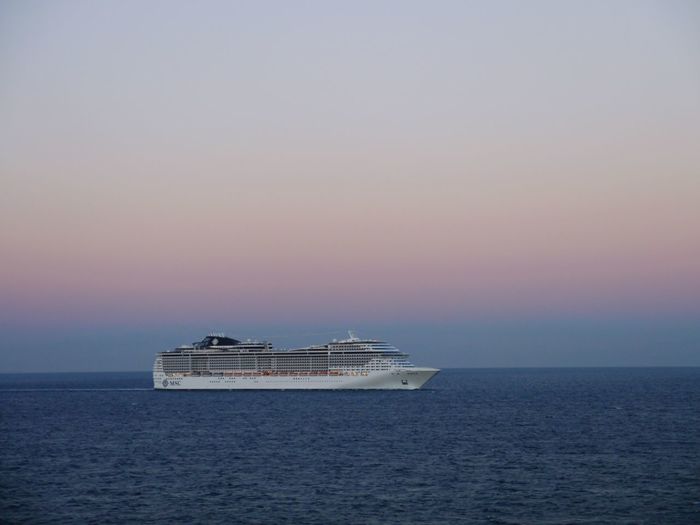 Ship sailing on sea against sky during sunset
