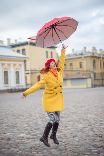Woman with umbrella standing on street
