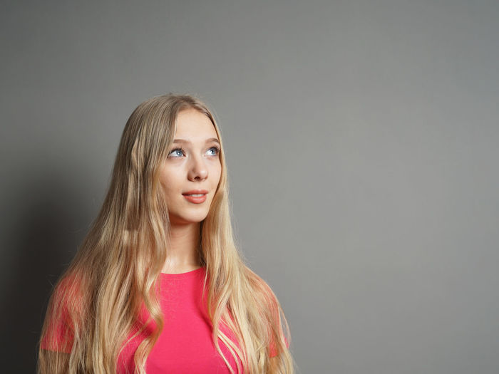 Portrait of a beautiful young woman against gray background