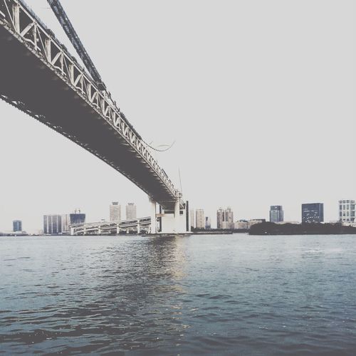Rainbow bridge over tokyo bay against clear sky
