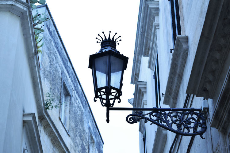Low angle view of street light on building against sky