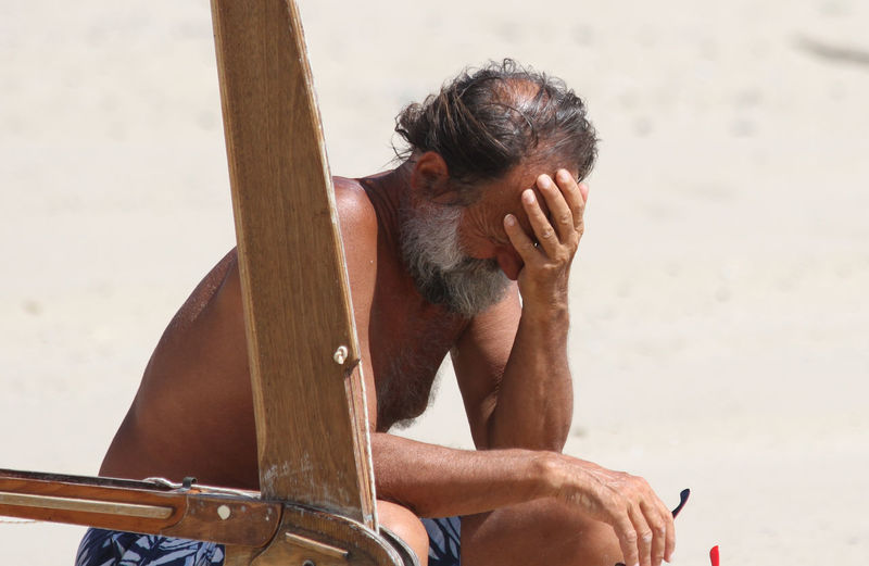Depressed man sitting at beach