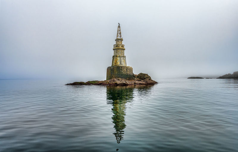 Fog around the lighthouse in the sea