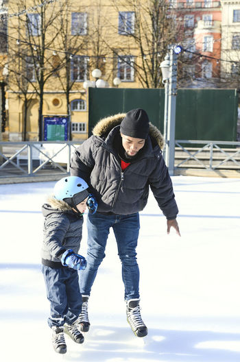 Full length of father and son in snow