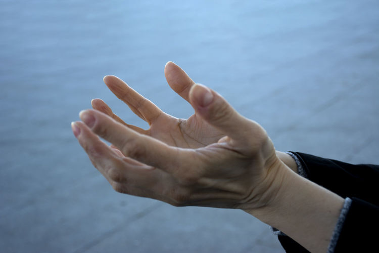 Cropped image of person hand against sea