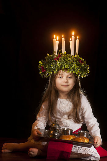 Close-up of girl holding illuminated candles