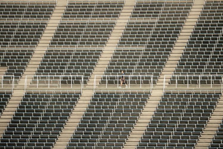 Full frame shot of empty stadium seating with one person