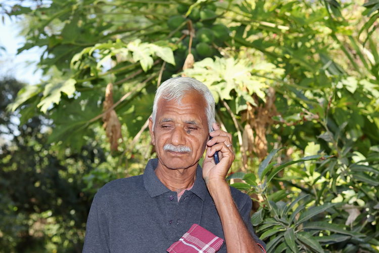 Closeup of senior farmer standing in a garden or field, taking advice from the agricultural officers 