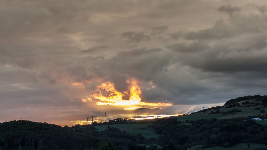Panoramic view of storm clouds over city during sunset