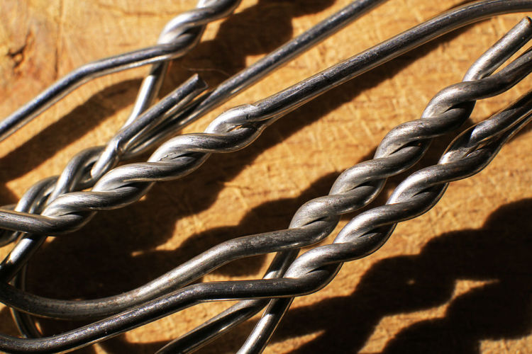 Macro photo, detail of iron hangers on wooden table background.