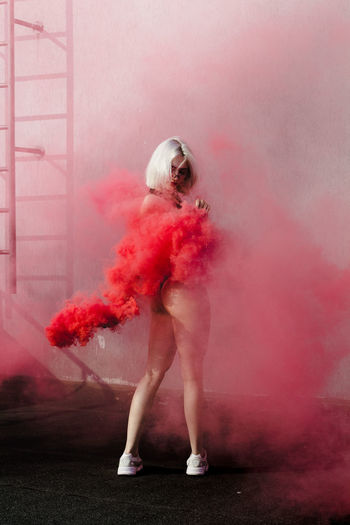 Full length of woman amidst red smoke