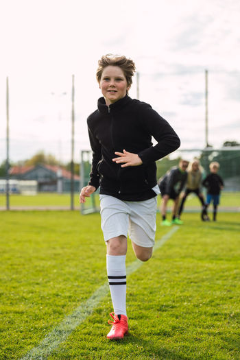 Full length of boy standing on soccer field