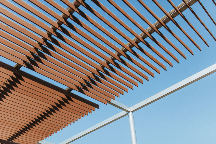 Low angle view of shade structure against clear blue sky