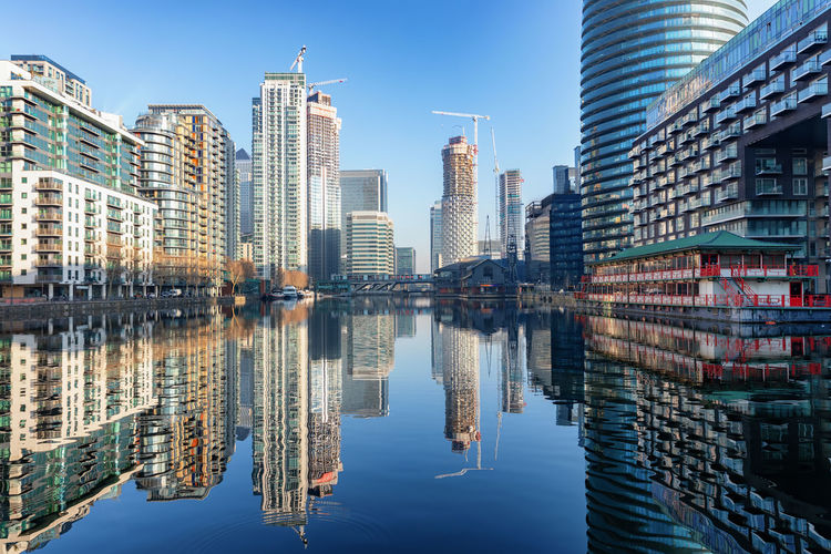 Reflection of buildings in city against sky