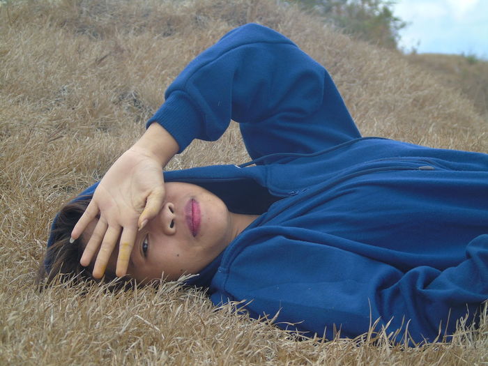 Portrait of woman lying on grass