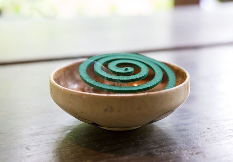 Close-up of mosquito coil in bowl on wooden table