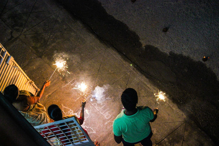 High angle view of people with sparklers at night