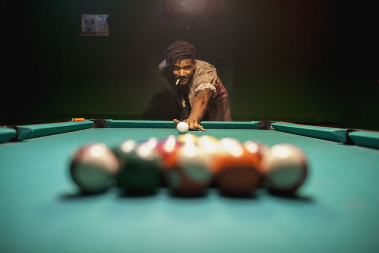 A young man playing pool. 
