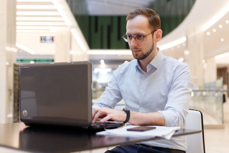 Young man using laptop at desk in office