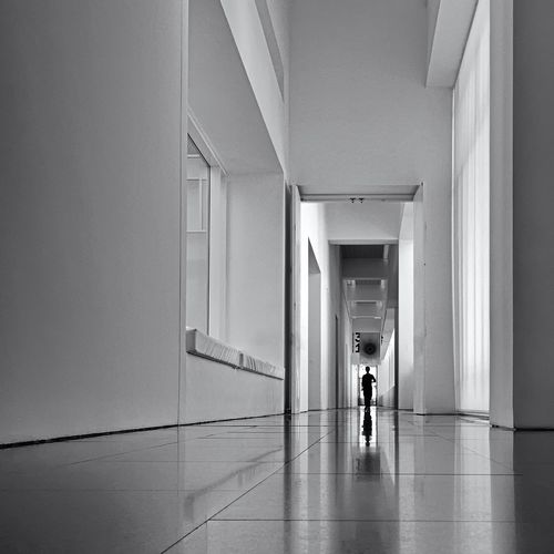 Rear view of man walking in corridor