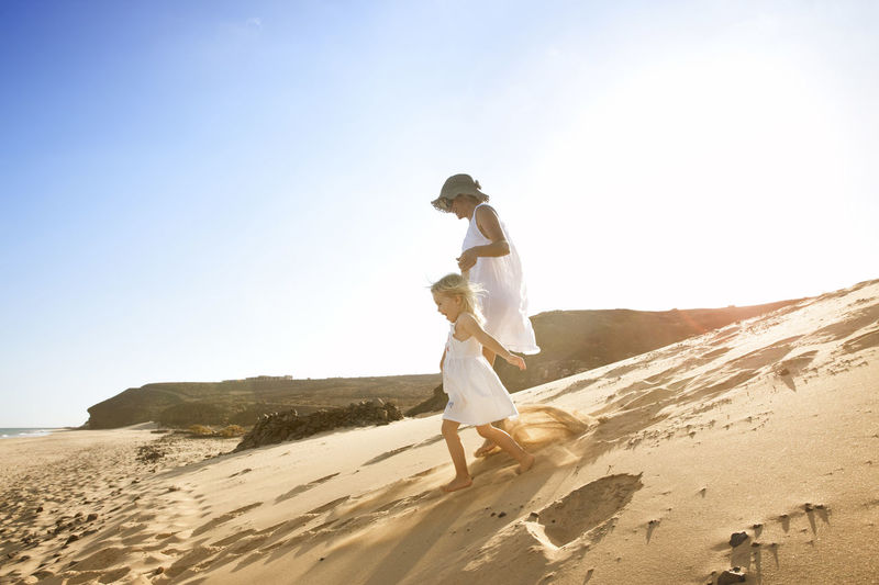 Spain, fuerteventura, mother running with daughter on the beach