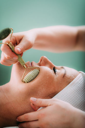 Guasha face massage in beauty salon, massage technique for stimulating pressure points on the face
