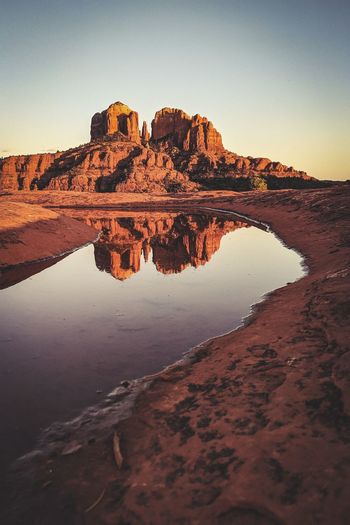 Reflection of cathedral rock off of a puddle at secret slickrock trail sedona arizona