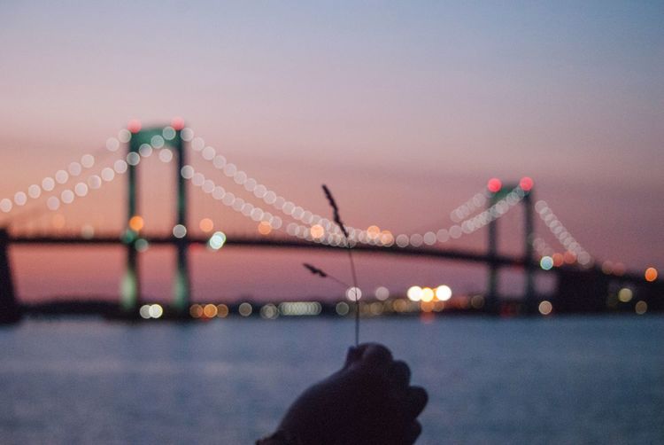 View of suspension bridge in city at dusk