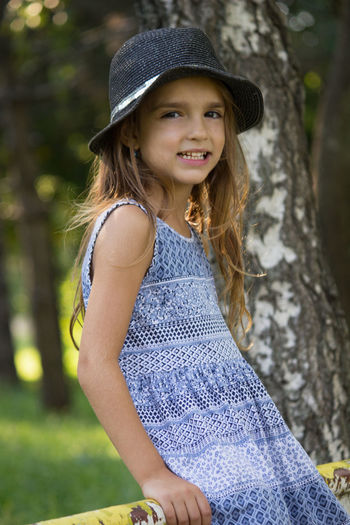 Portrait of smiling girl wearing hat at park