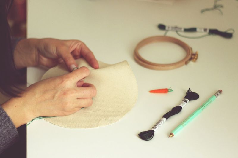 Human hands embroidering cloth